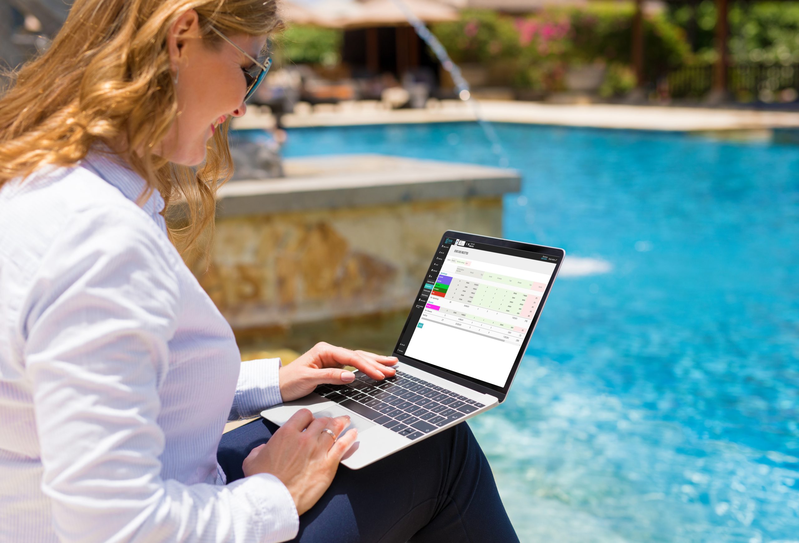femme d affaires utilisant un ordinateur portable en vacances dans un complexe au bord de la piscine